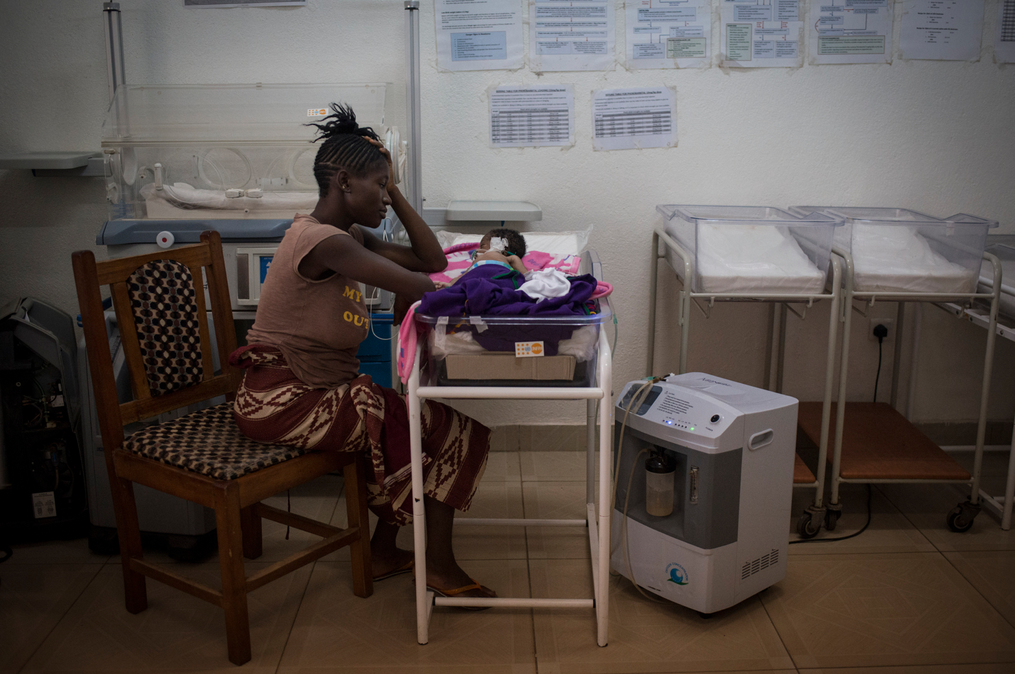 Kema James watching her baby boy in the neonatal intensive care unit three days after giving birth at Kenema Government Hospital in Kenema, Sierra Leone. The baby was born with sepsis and died at five days old. Nov. 12, 2015.